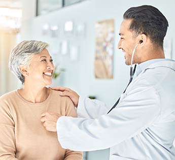 a male doctor examining an older female patient