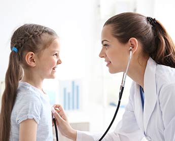 a female doctor examining a little girl